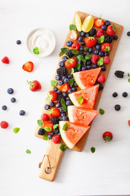 Plato de frutas y bayas sobre blanco. arándano, fresa, frambuesa, mora, sandía