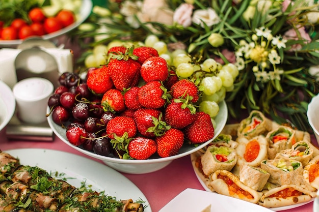 Plato de frutas la mesa está cubierta con catering Frutas y bayas Decoración de mesa de boda