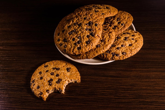 Plato con galletas de chispas de chocolate en una mesa de madera oscura