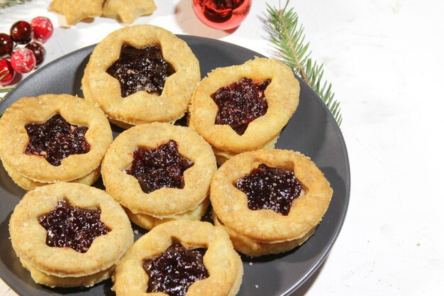 Plato con galletas de masa quebrada con mermelada de frutos rojos Galletas caseras tradicionales para vacaciones