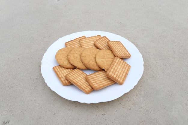 Un plato de galletas con un plato blanco sobre la mesa.