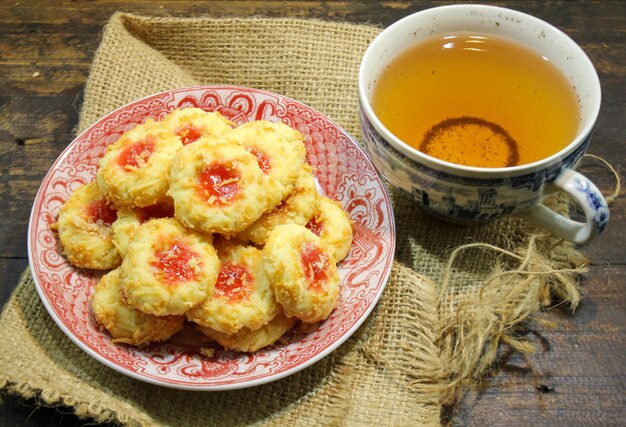 Un plato de galletas con una taza de té al lado