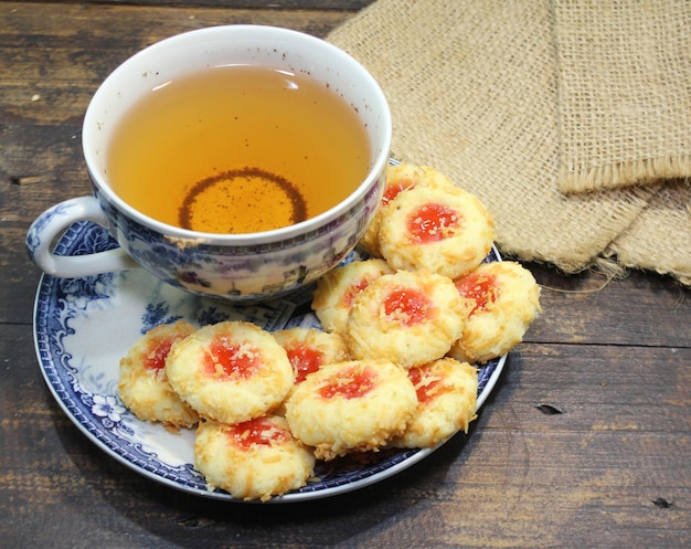 Un plato de galletas con una taza de té al lado