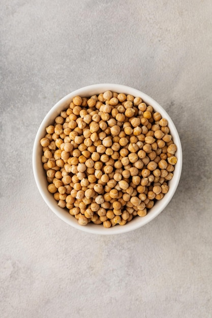 Un plato de garbanzos crudos sobre un fondo claro