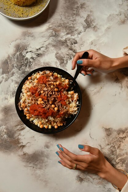 Un plato de garbanzos con un plato negro de salsa de tomate