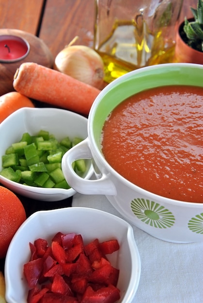 Plato de gazpacho con tomate, aceite y varios vegetales.