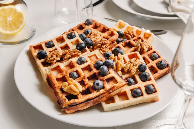 Plato con gofres vieneses decorado con nueces y arándanos.