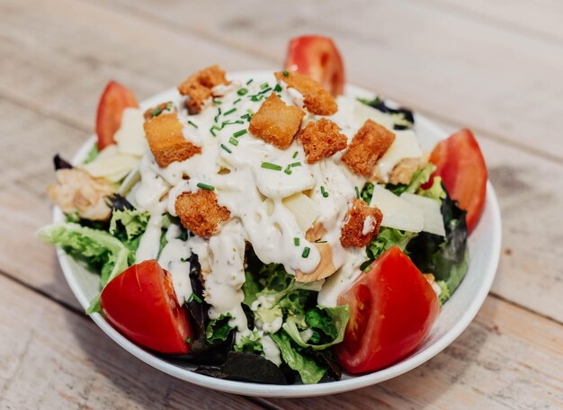 Plato gourmet de ensalada César con pollo a la parmesana y pan crujiente