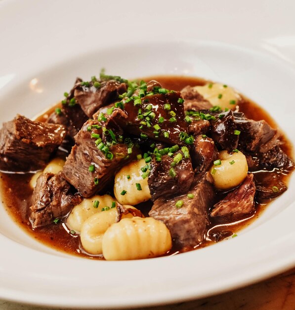 Foto plato gourmet de gnocchi con carne de res