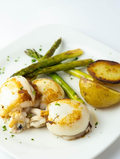 Plato gourmet de sepia con patatas asadas y espárragos