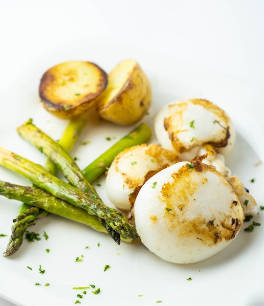 Plato gourmet de sepia con patatas asadas y espárragos