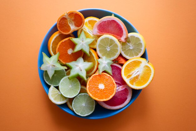 Plato grande con rodajas de cítricos sobre fondo naranja