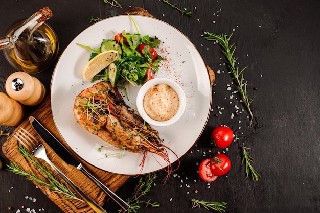 Foto plato de grandes camarones con hierbas sobre fondo de madera