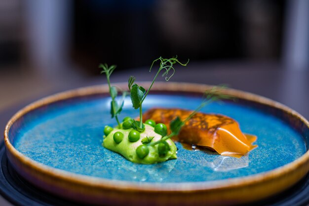 Foto un plato con guisantes y zanahorias con un vegetal verde