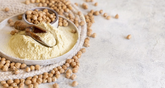 Plato de harina de garbanzos crudos y frijoles en el cuadro blanco de cerca