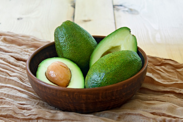 En el plato hay aguacates sobre un fondo de madera.