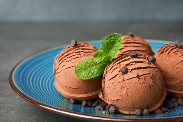 Plato de helado de chocolate con menta en el primer plano de la mesa gris