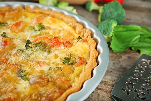 Plato para hornear con sabroso quiche de brócoli en primer plano de la mesa