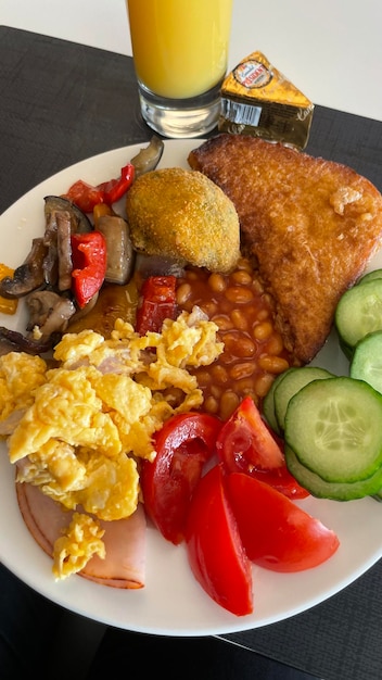 Foto un plato de huevos, tomates y pepino.