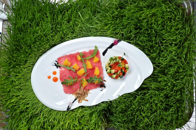 Un plato italiano de carpaccio de atún con tartar de verduras