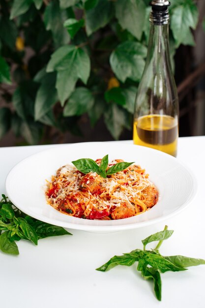 Plato italiano pasta de espaguetis albóndigas con vinagre sobre la mesa blanca