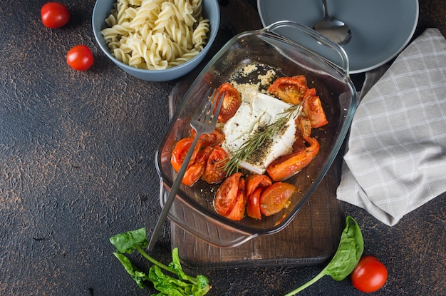 Plato italiano de pasta mezclada con queso Feta al horno y tomates sobre un fondo oscuro Fetapasta