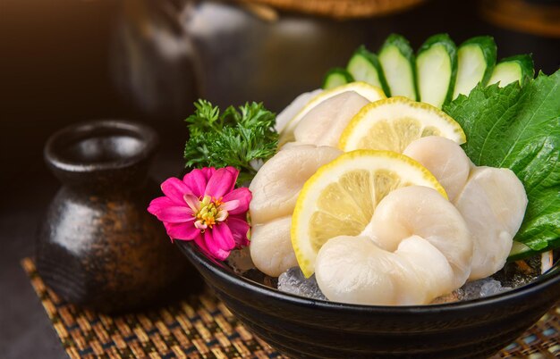 Foto plato japonés hecho con vieiras cortadas en rebanadas delgadas