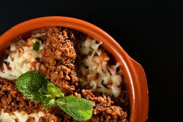 Un plato de lasaña con una ramita de menta encima.