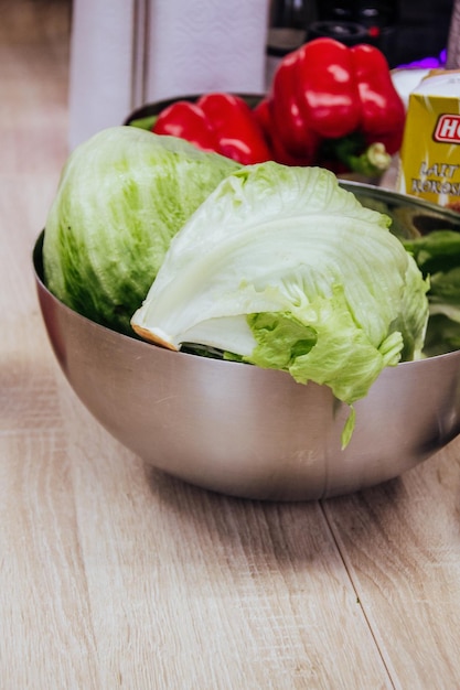 Un plato de lechuga con una botella de mostaza al lado.