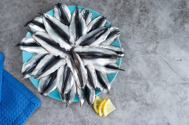 Plato lleno de anchoas sobre fondo de mármol