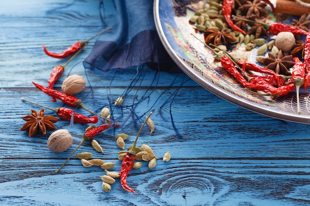 Plato lleno de especias asiáticas con chile en mesa azul