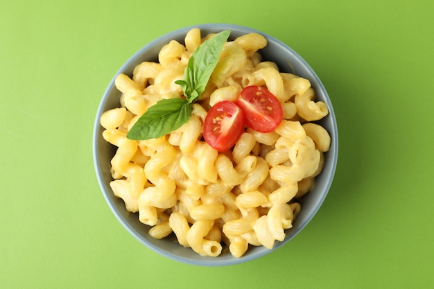 Plato con macarrones con queso sobre fondo verde