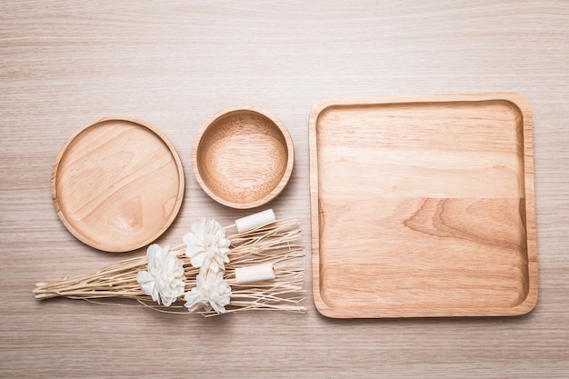 Plato de madera con la flor secada en el fondo de madera.