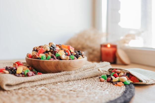 Plato de madera con frutas confitadas y frutos secos en un puesto de mimbre en el contexto de un concepto ecológico de velas