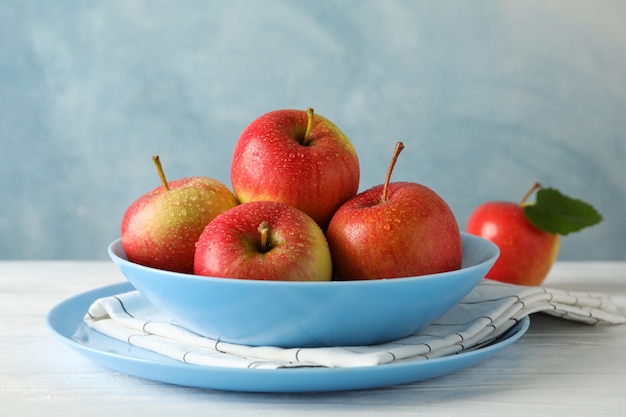 plato y manzanas en la mesa de madera blanca