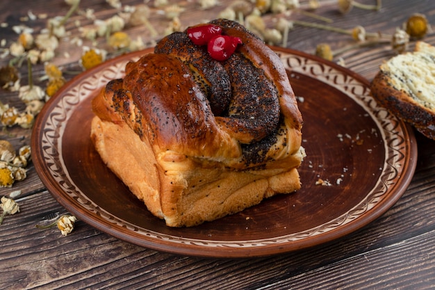 Plato marrón de pastelería fresca con salsa de chocolate sobre mesa de madera.