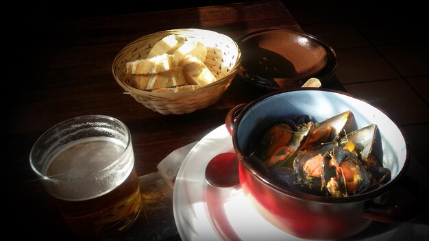 Un plato de mejillones junto a un plato de cerveza.