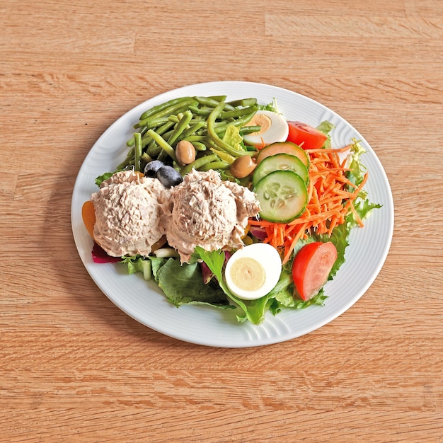 Plato con melocotón y atún sobre mesa de madera