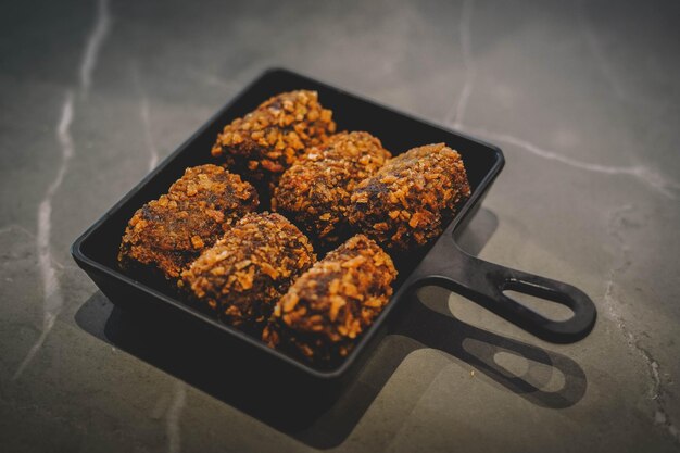 Un plato negro de comida con un asa negra que dice 'falafel'