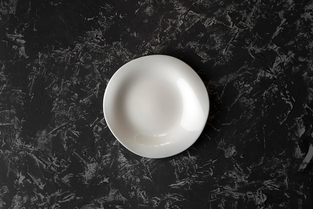 Plato o plato de cerámica limpio y vacío sobre una superficie de concreto