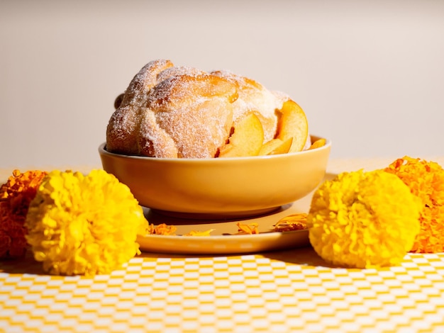 un plato de pan con flores y un cuenco de granadas