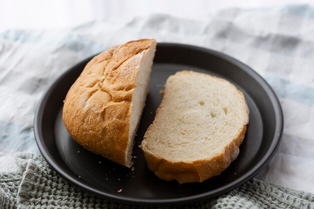 Un plato de pan con una rebanada cortada.