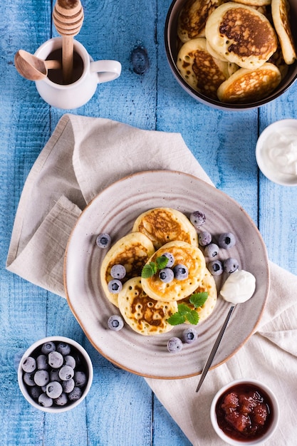 Un plato de panqueques con crema agria de arándanos y menta Pastelería casera Vista superior y vertical