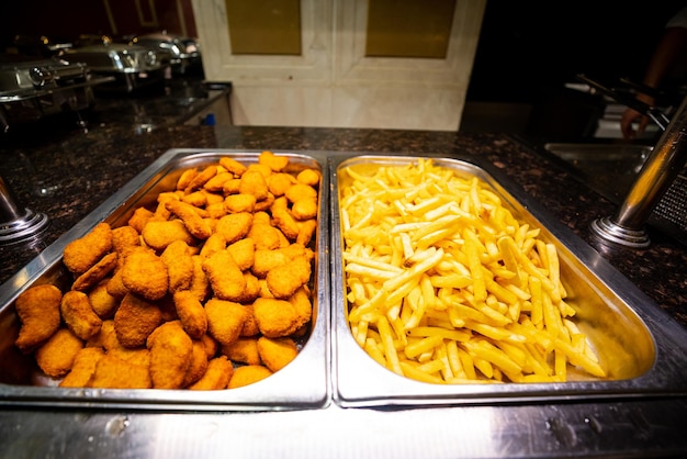 Foto un plato de papas fritas doradas y nuggets de pollo en un ambiente de hotel de lujo perfecto para una comida rápida y satisfactoria
