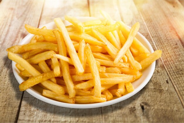 Foto plato de papas fritas en una mesa de madera