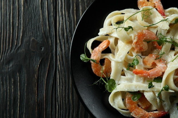 Plato de pasta de camarones sobre fondo de madera rústica