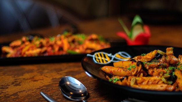 Un plato de pasta con una cuchara en la mesa de al lado