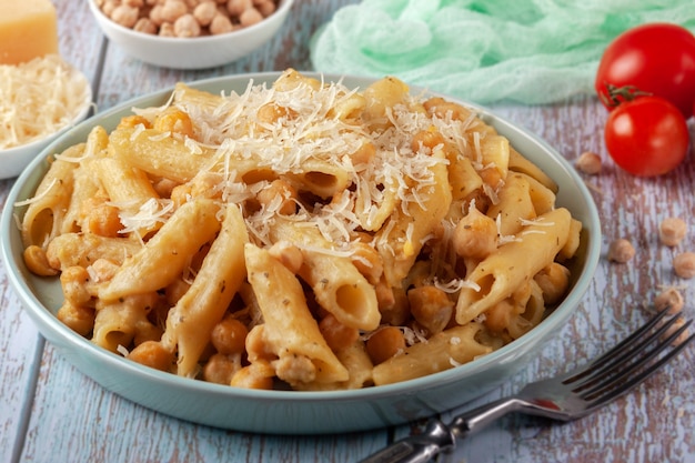 En un plato de pasta italiana con garbanzos, especias y tomates - closeup