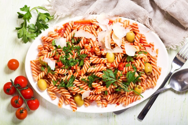 Plato de pasta penne con salsa de tomate y perejil