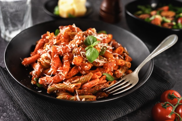 Plato de pasta penne con salsa de tomate y queso